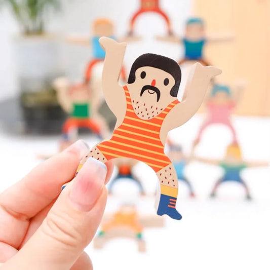 Hand holding a small figurine of a cartoon character with a mustache in a blurred indoor setting.
