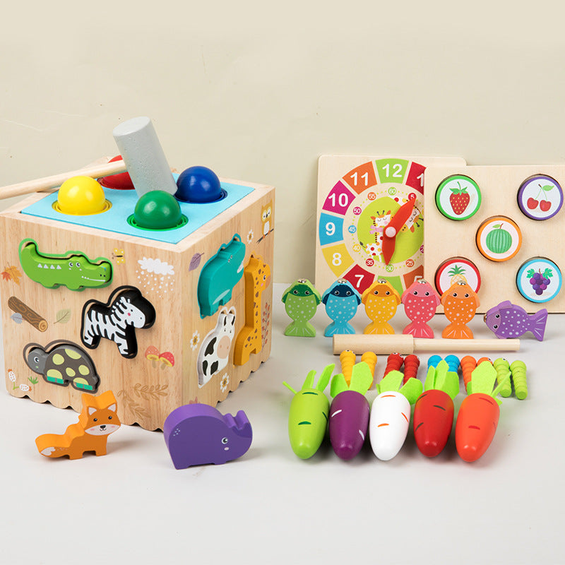 Set of wooden educational toys including a shape sorting cube, number clock, and vegetable sorting toy on a light background.