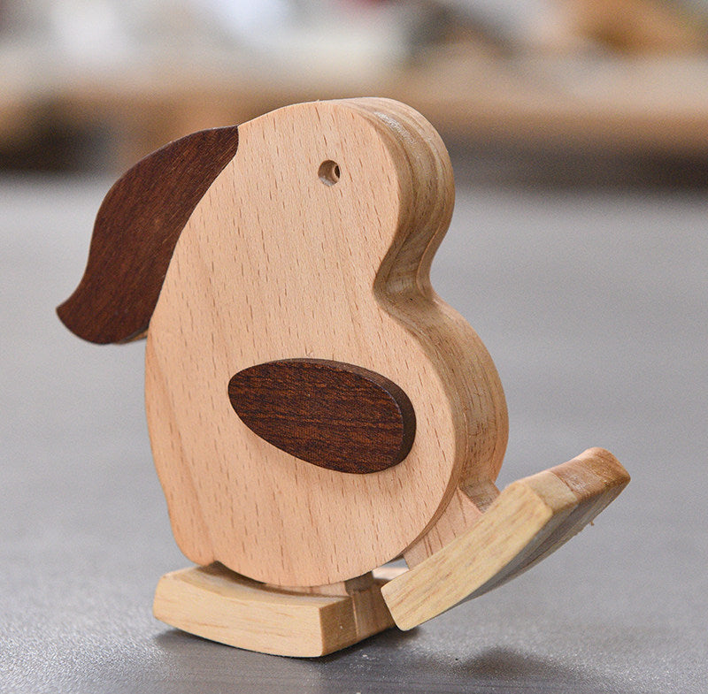 Wooden rabbit-shaped ramp walker toy on a gray surface