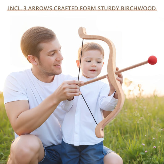 Man and child holding a wooden bow and arrow set in a grassy field.