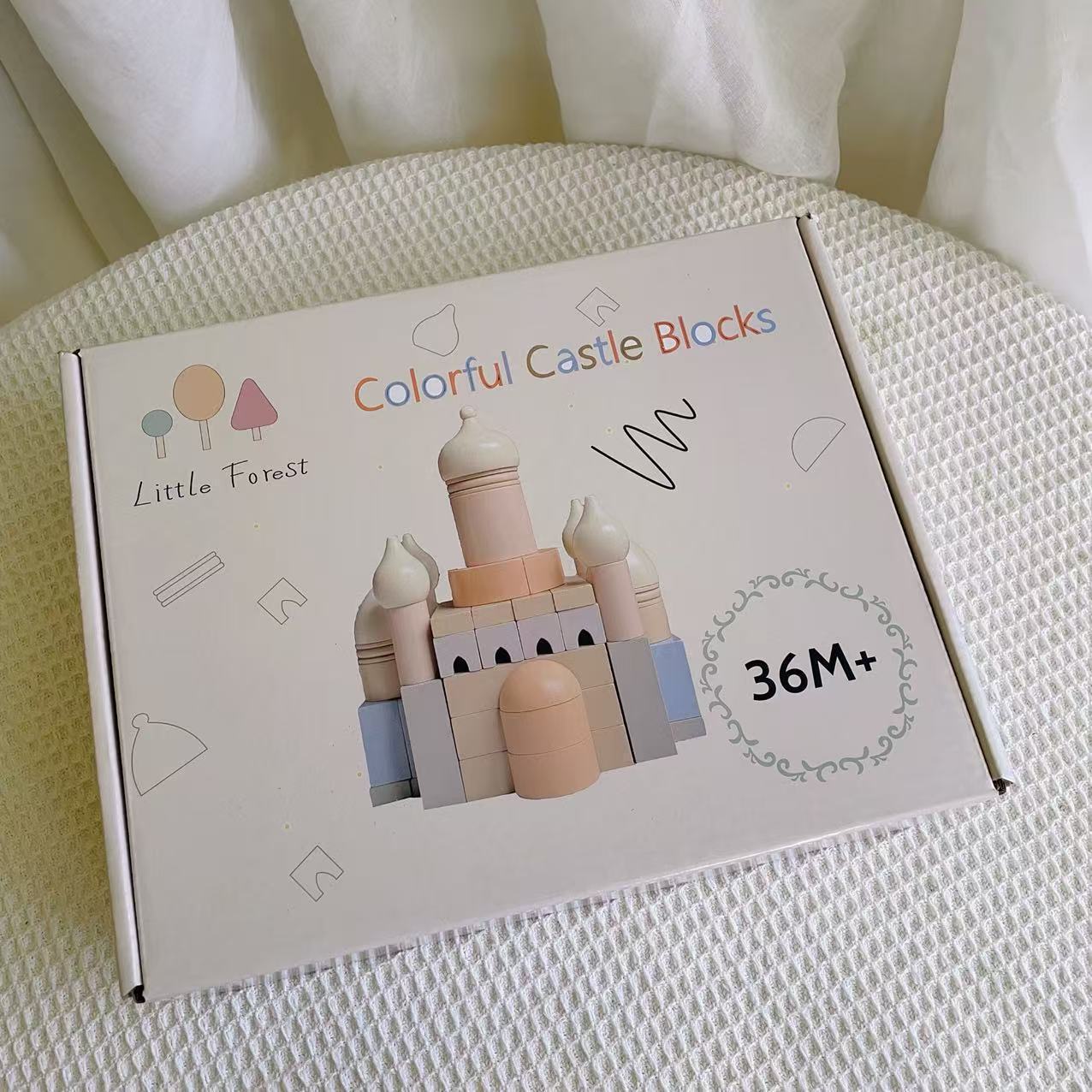 Box of 'Colorful Castle Blocks' by Little Forest on a textured surface