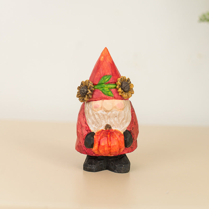 Decorative gnome figurine with a red hat and pumpkin, on a beige surface with a light background
