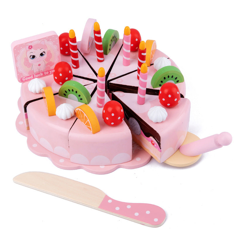 Toy birthday cake with fruits and candles on a white background