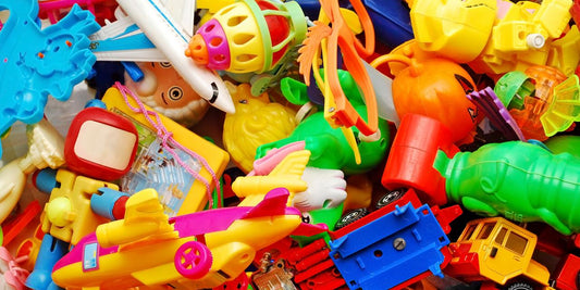 Pile of assorted colorful plastic toys including planes, trucks, robots and animals