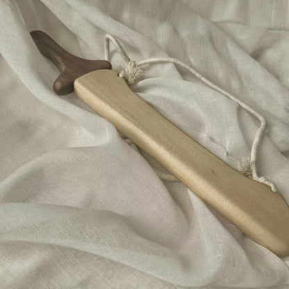 Handcrafted wooden toy sword with natural finish and rope, sustainable Montessori play