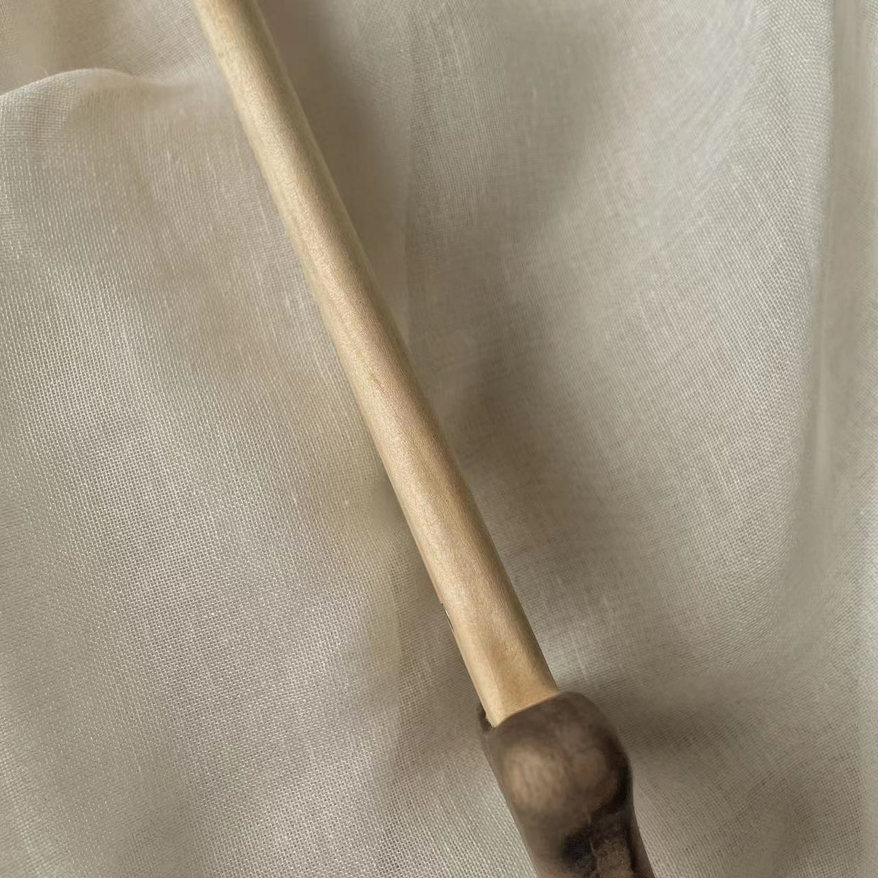 Handcrafted sustainable wooden toy stick on beige fabric background