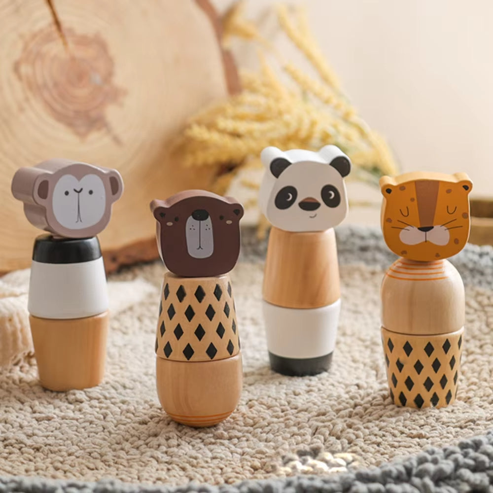 Four wooden animal figurines on a textured surface with a blurred natural background
