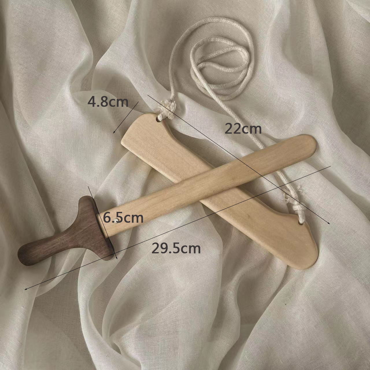 Handcrafted Montessori wooden toy sword and hanger with rope, eco-friendly, on fabric background