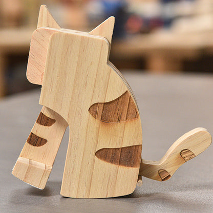 Wooden cat-shaped toy on a gray surface with a blurred background