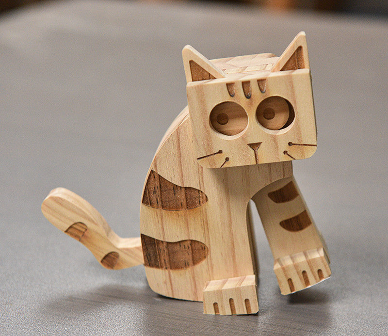 Wooden cat figurine on a gray surface