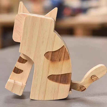 Wooden cat-shaped object on a gray surface with a blurred background