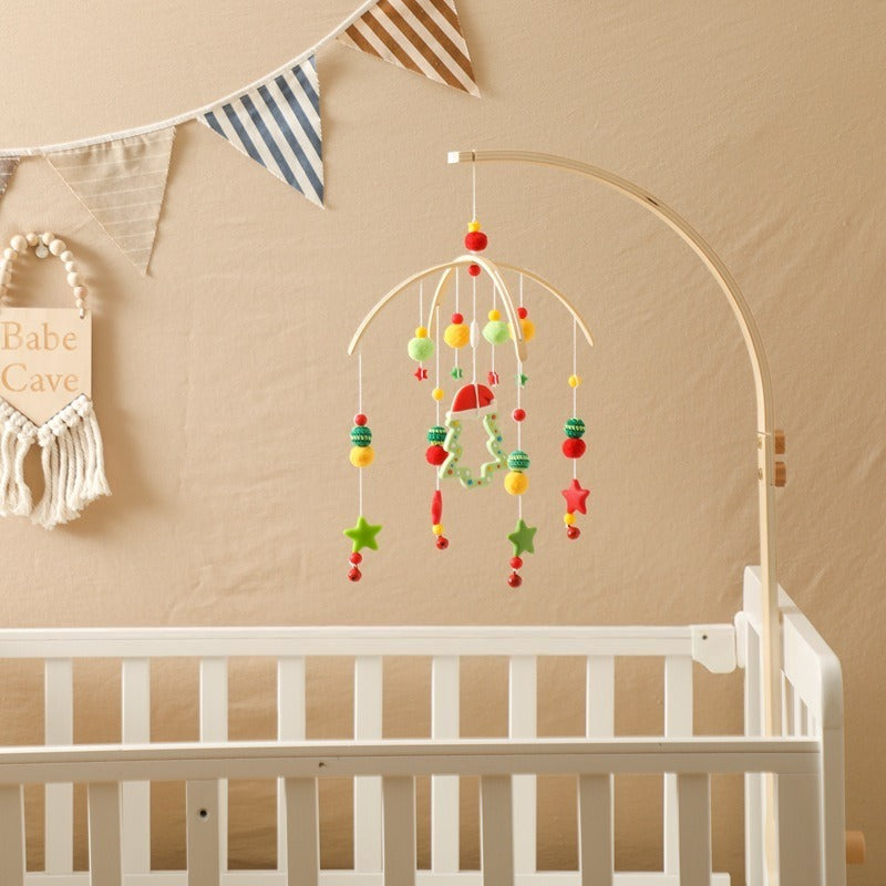 Colorful baby mobile hanging above a white crib with a beige wall and decorative elements.