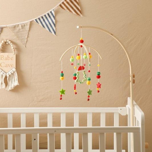 Colorful baby mobile hanging above a white crib with a beige wall and decorative elements.