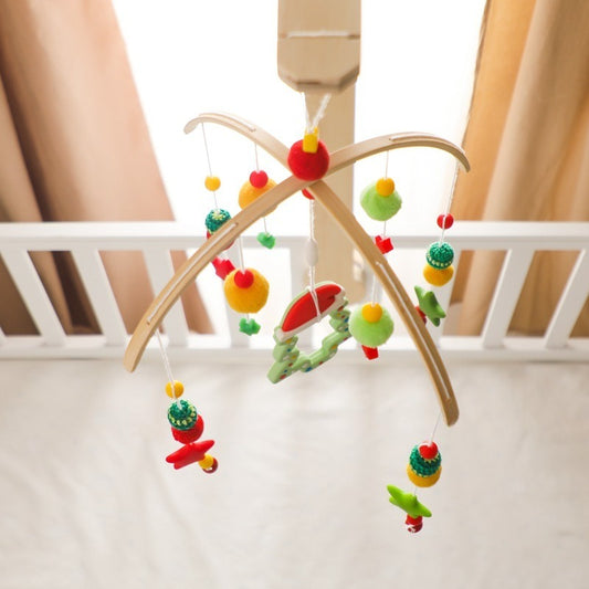 Colorful baby mobile hanging above a crib with curtains in the background