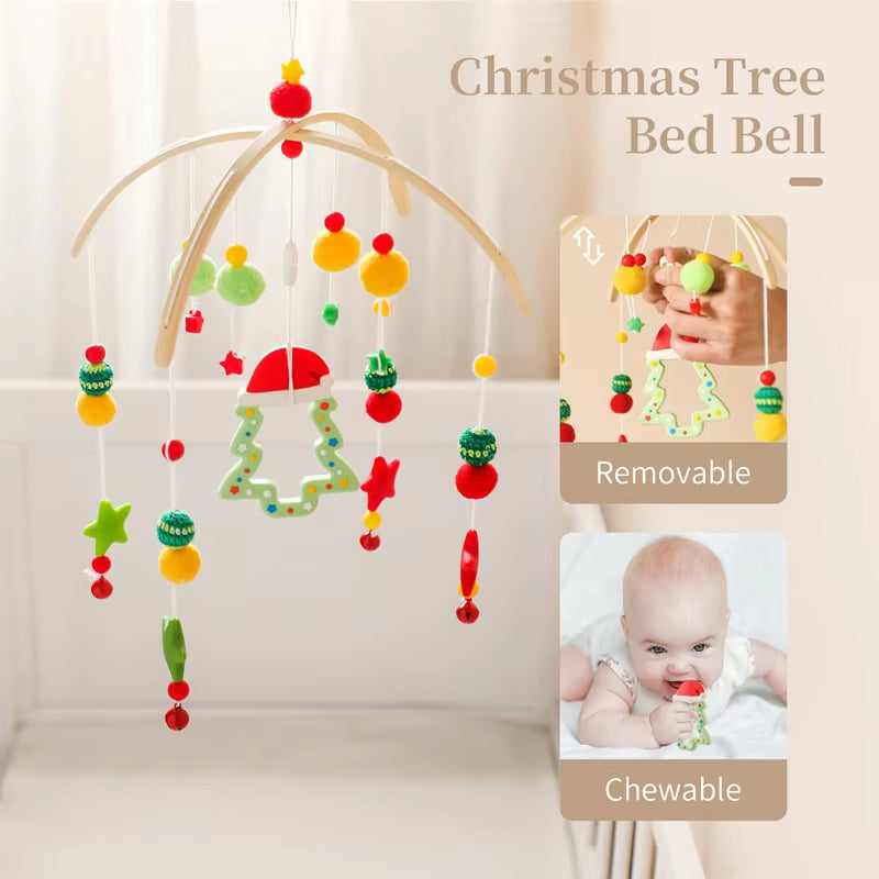 Christmas tree bed bell with colorful hanging decorations and a baby holding it.