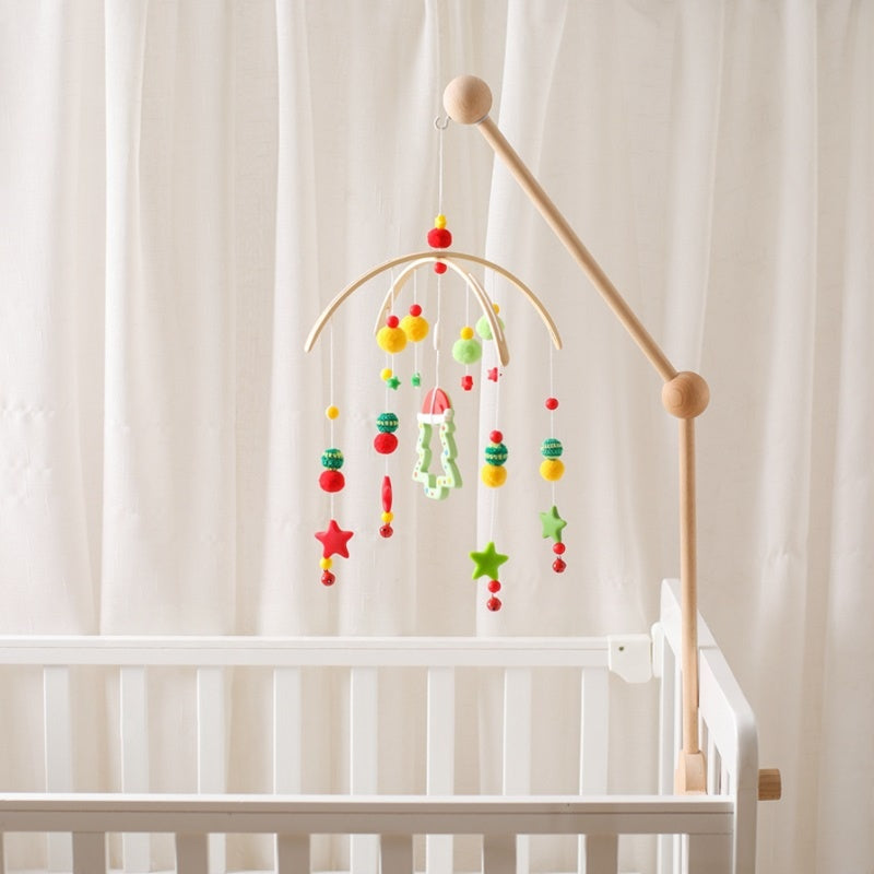 Colorful baby mobile hanging above a crib with a white curtain background