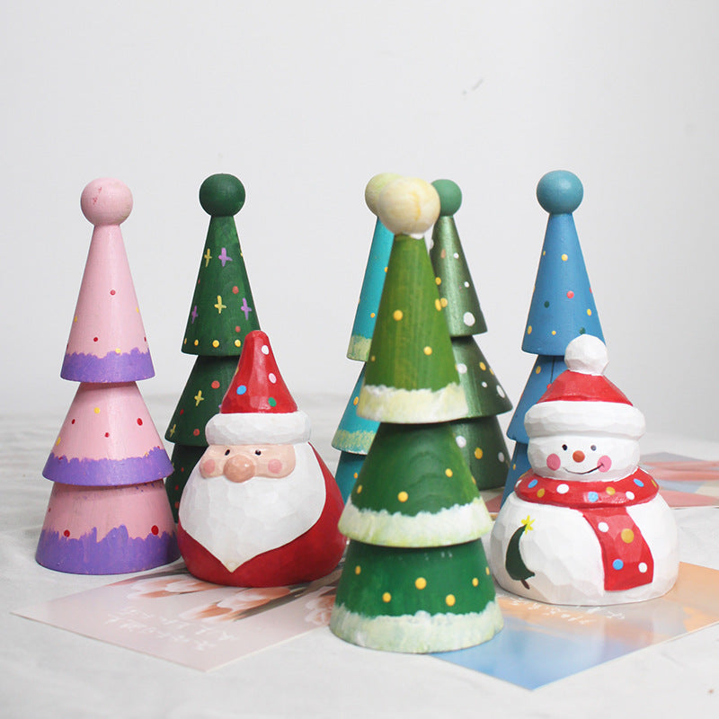 Colorful wooden Christmas decorations including trees and Santa Claus on a white background
