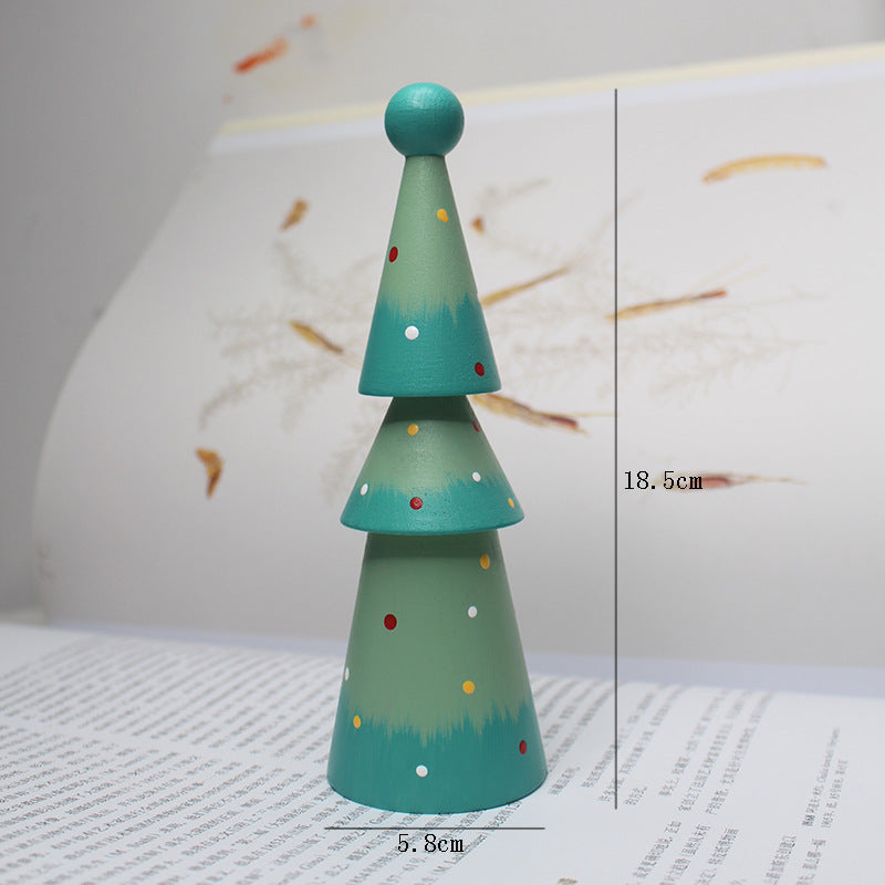 Green wooden Christmas tree ornament with colorful dots on a white surface