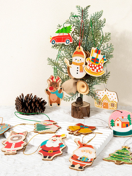 Collection of colorful Christmas tree ornaments on a white surface with a small tree in the background.