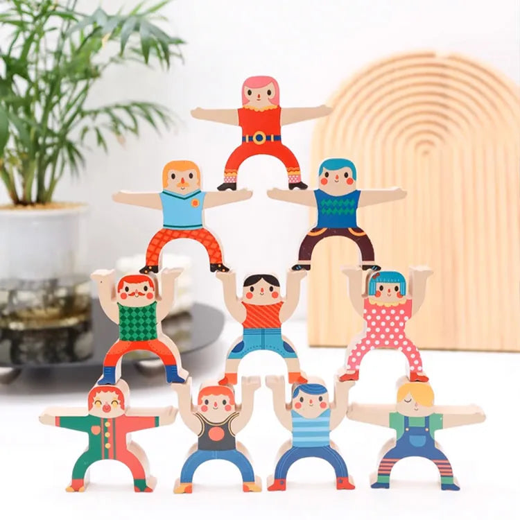 Colorful wooden toy figures arranged in a pyramid formation on a white surface.