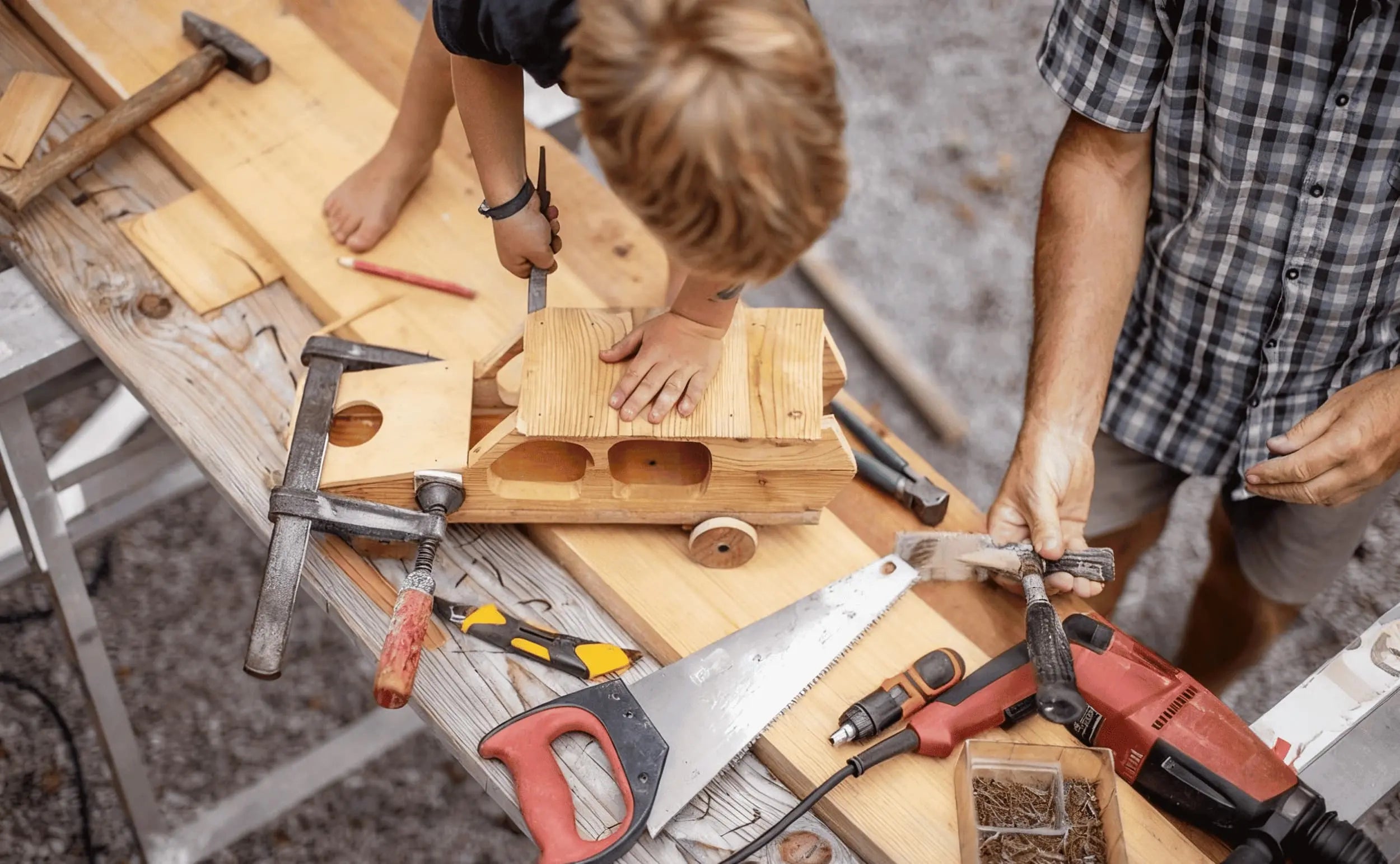 A grandfather making custom wooden toys together with his grandson