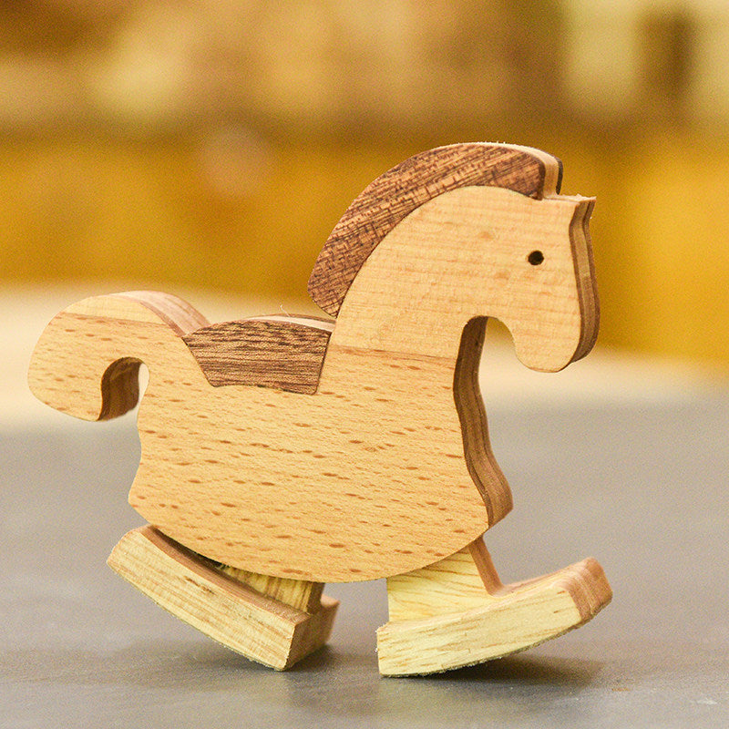 Natural wood horse toy walking down a slope through mechanical physics.