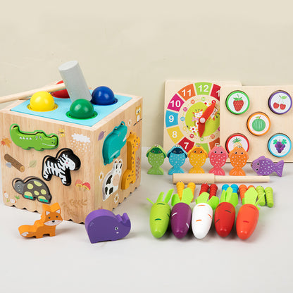 Set of wooden educational toys including a shape sorting cube, number clock, and vegetable sorting toy on a light background.