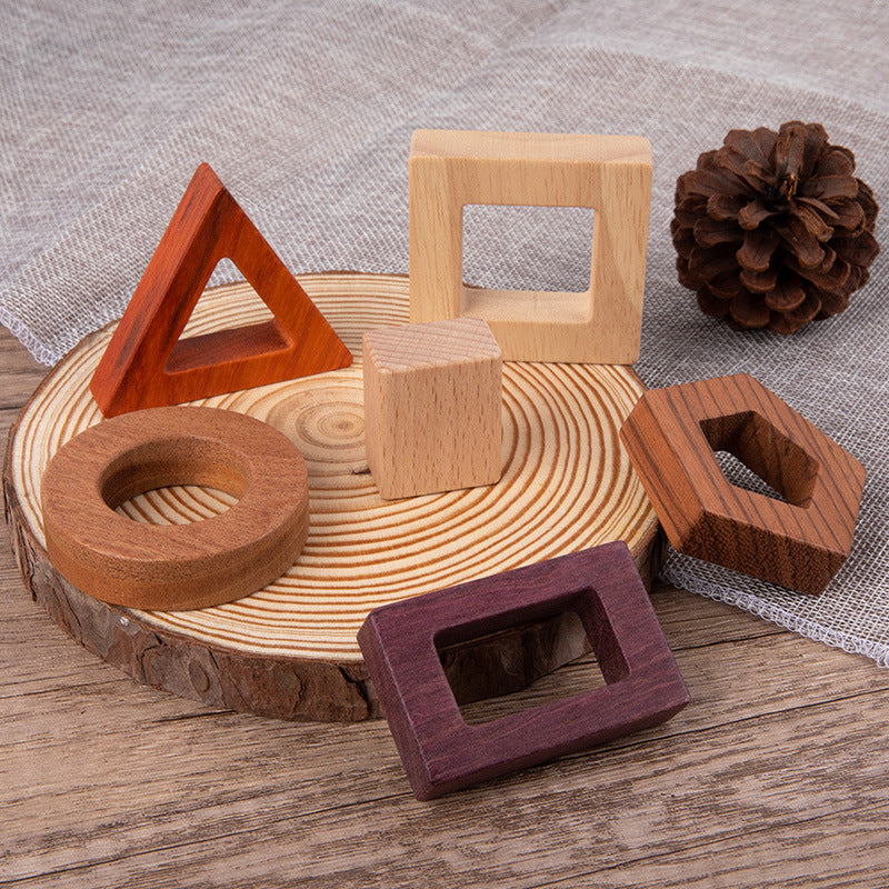 Wooden geometric shapes on a wooden surface with a pine cone.