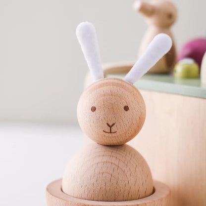Wooden toy rabbit with white ears on a light background