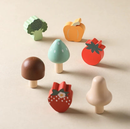 Set of colorful wooden toy fruits and vegetables on a beige background