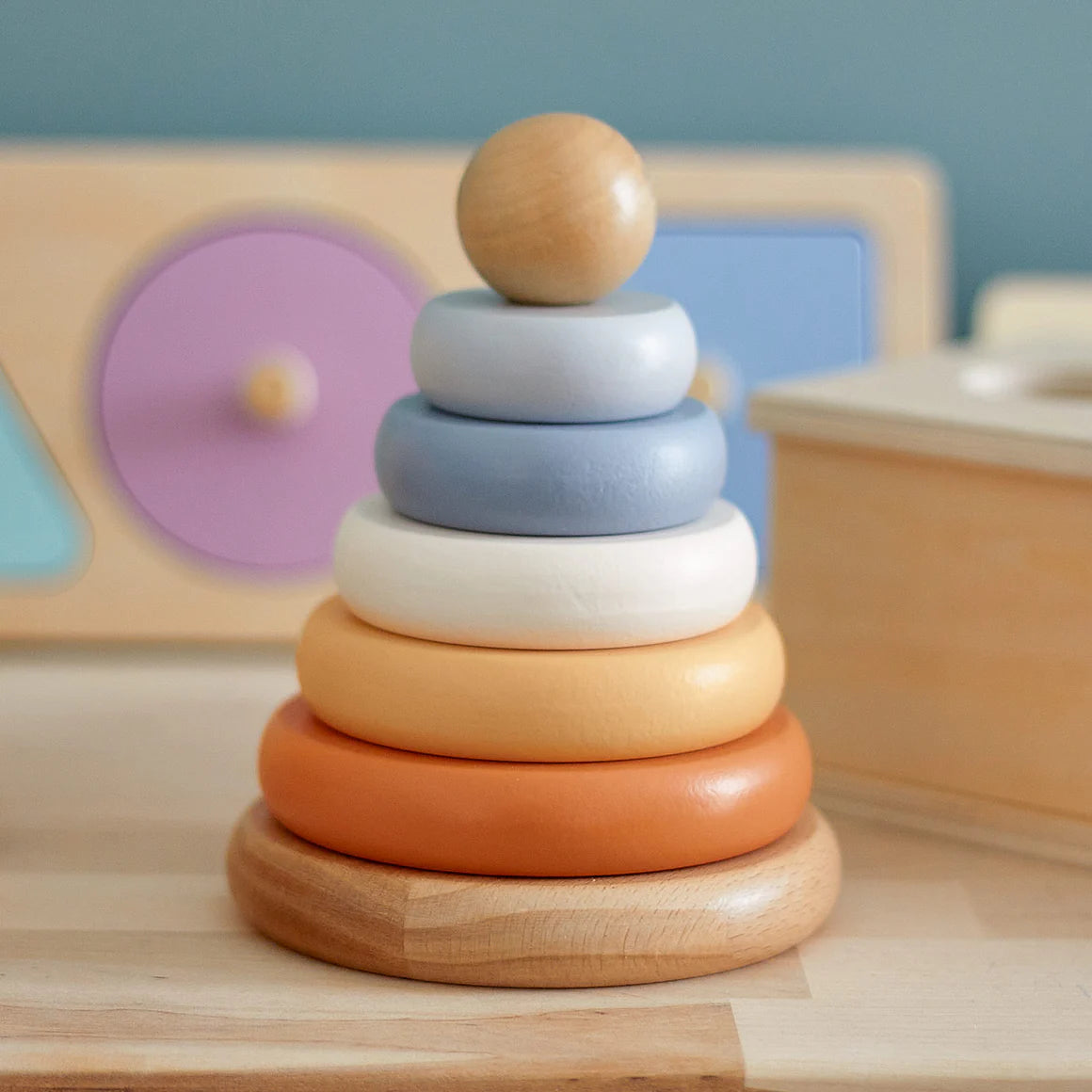 Stack of wooden rings in various colors on a wooden surface with a blurred background