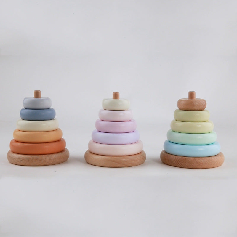 Three wooden ring stacking toys in pastel colors on a white background