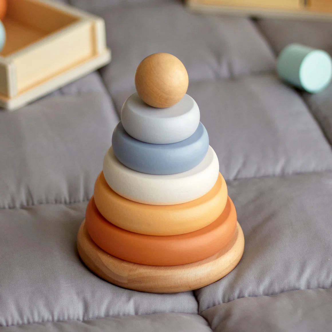Wooden stacking toy with colorful rings on a soft surface