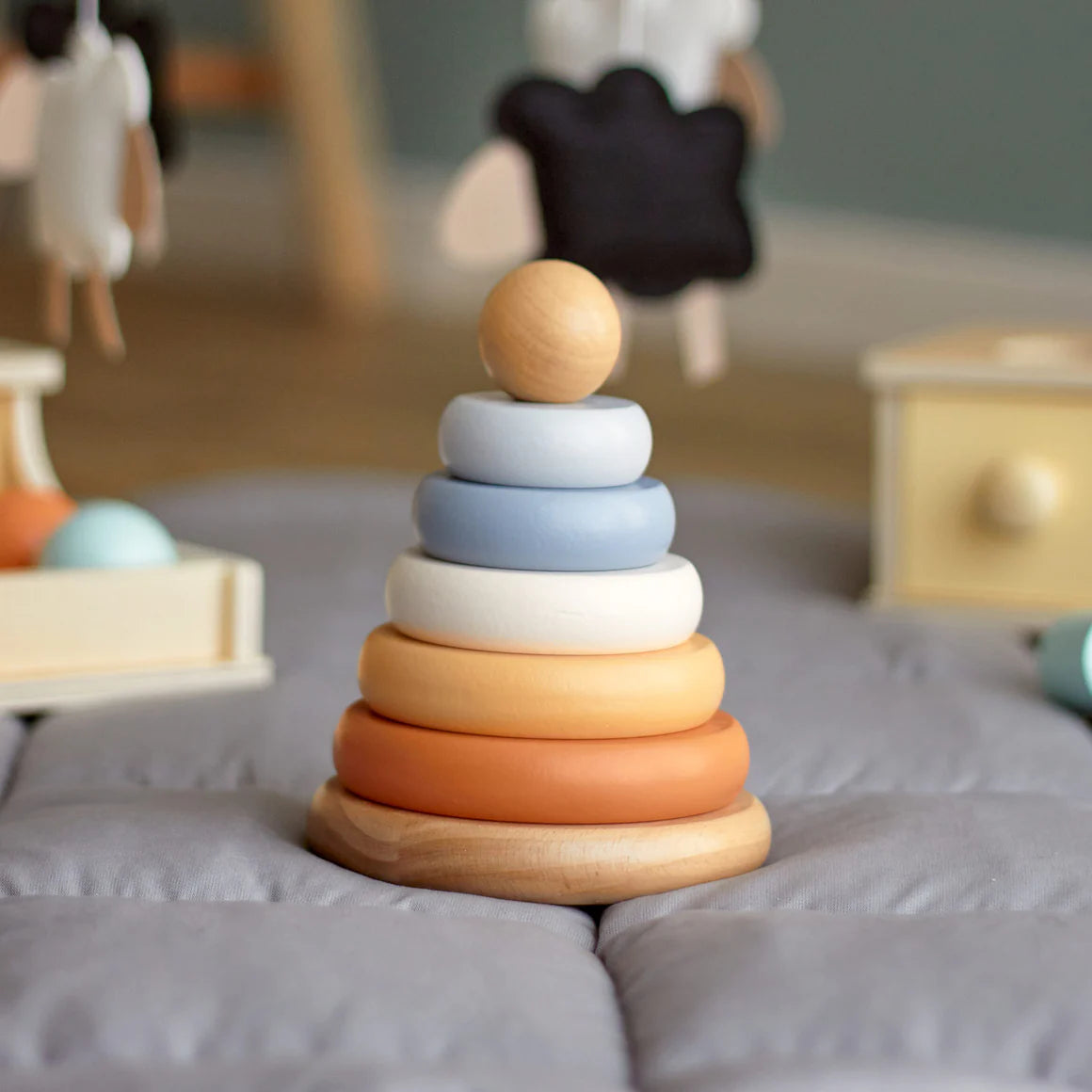 Stack of wooden rings in various colors on a soft surface