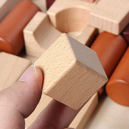 Hand holding a wooden block among other wooden blocks.