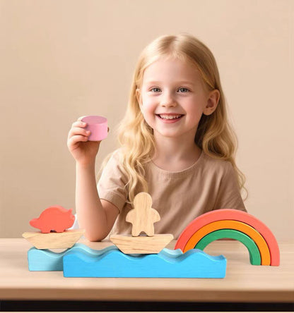Smiling child playing with Montessori rainbow wooden toy blocks on a table
