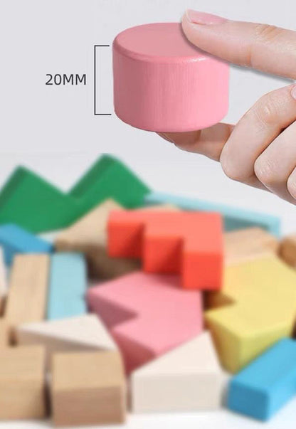 Hand holding a pink 20mm wooden block above colorful Montessori toy blocks set