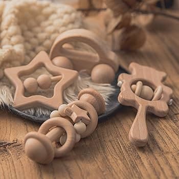 Wooden baby toys on a wooden surface with a soft fabric background