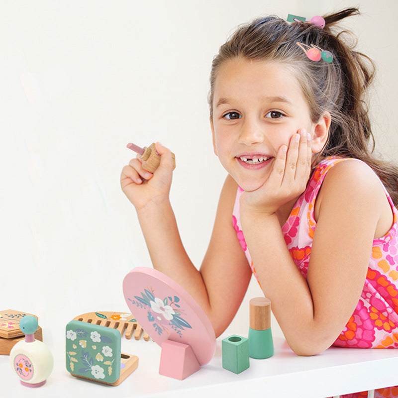 Smiling girl playing with Montessori wooden kids makeup play set, eco-friendly and handcrafted.