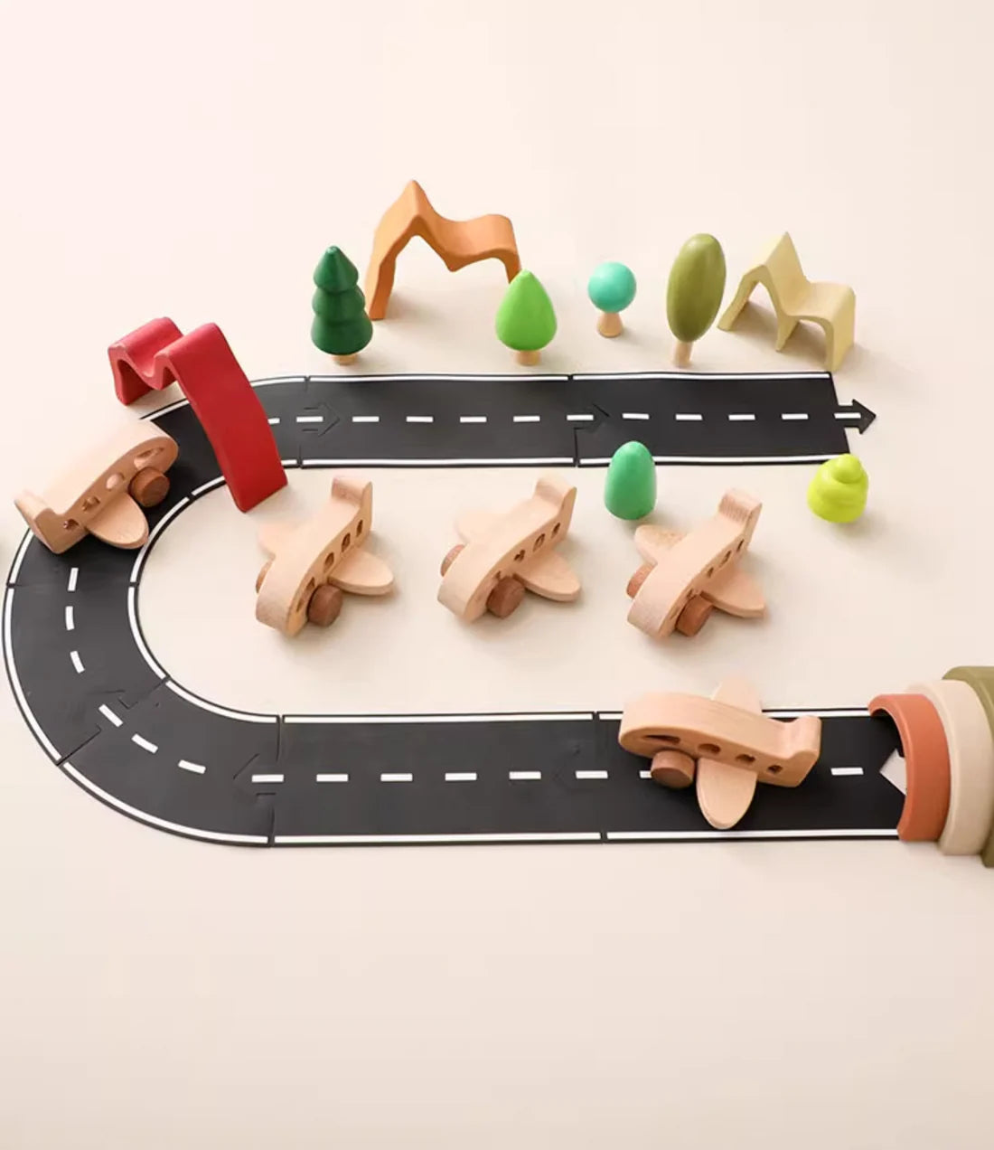 Wooden toy road with cars and trees on a light beige background