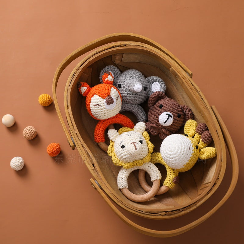 Wooden basket with crocheted animal toys on a brown background