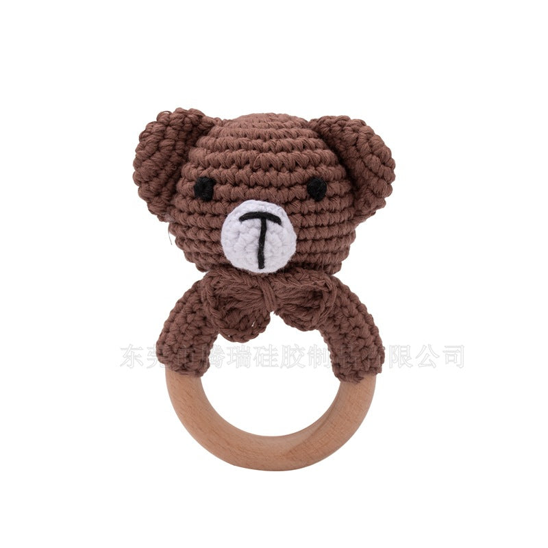 Brown teddy bear-shaped rattle with a wooden ring on a white background
