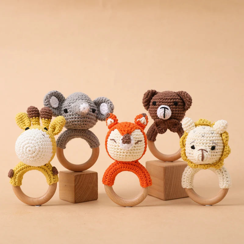 Set of animal-themed wooden rings with crochet animal heads on a beige background