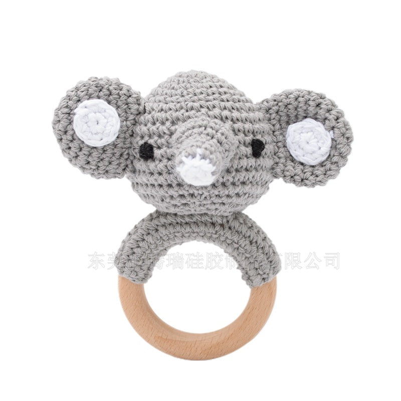 Gray knitted mouse-shaped rattle with a wooden ring on a white background