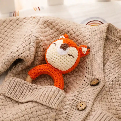 a wooden fox rattle toy on a textured beige fabric cloth