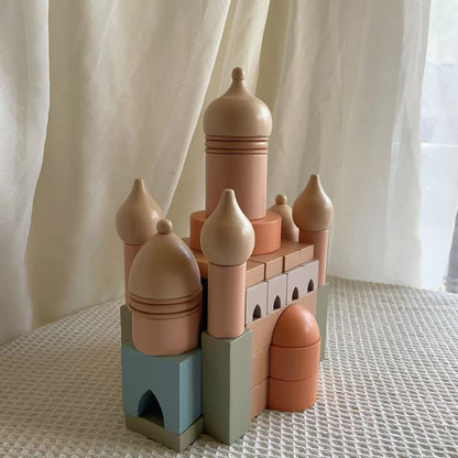 Toy castle made of interlocking blocks on a textured surface with a light curtain background