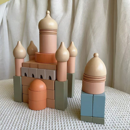 Colorful toy castle made of interlocking blocks on a textured surface with a neutral background
