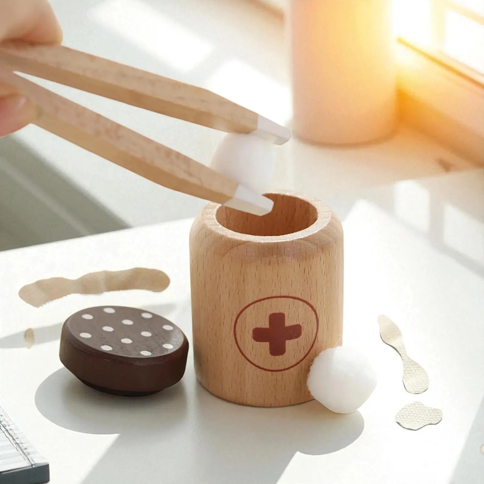 Wooden toy set with cylindrical container, round brown block, and other wooden pieces on a light surface.