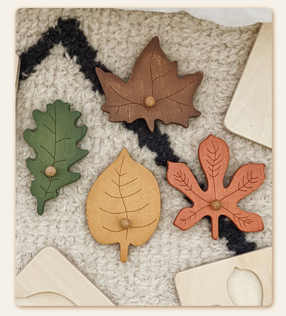 Set of wooden leaf-shaped toys on a textured surface