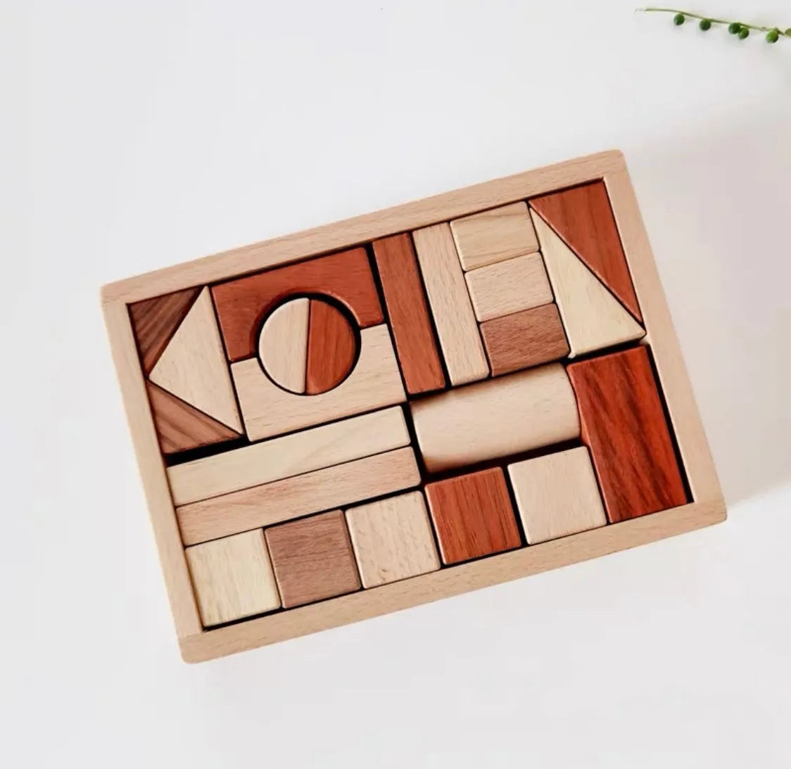 Wooden block puzzle with various shapes on a white surface